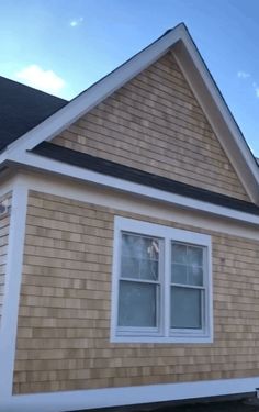 a brown house with white trim and windows on the side of it's roof