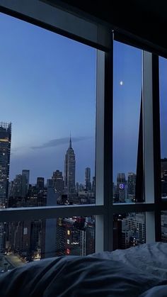 a bedroom with a view of the city at night