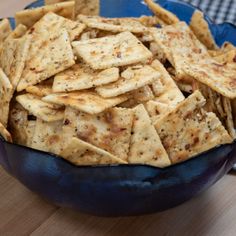 a blue bowl filled with crackers on top of a wooden table