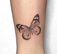 a black and white butterfly tattoo on the right leg, it looks like an image of a