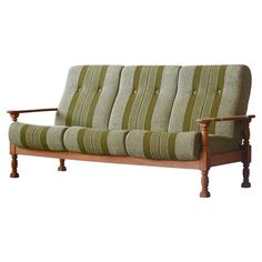 a green and white striped couch with wooden legs