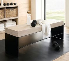 a modern daybed with storage and towels in the background, along with other items