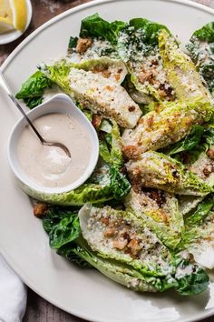 a white plate topped with lettuce covered in sauce