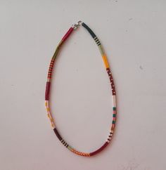 a multicolored beaded necklace on a white surface