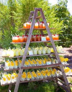 a wooden stand with orange juices and lemonade cups on it's sides