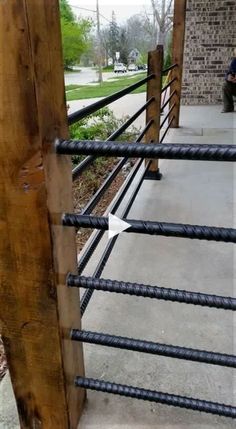 a man sitting on a bench next to a metal fence