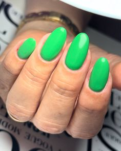 a woman's hand with green nail polish on it