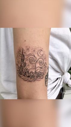 a person with a tattoo on their arm that has an image of a boat in the water