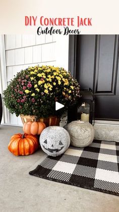 a black and white checkered door mat with pumpkins and flowers in front of it