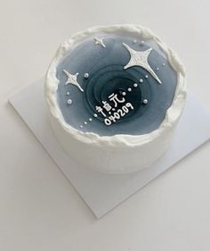 a blue and white cake sitting on top of a piece of paper