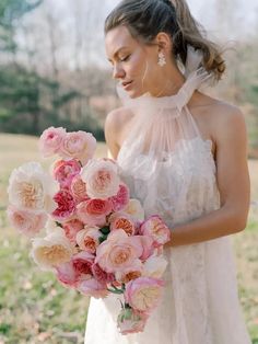 a woman in a white dress holding a bouquet of flowers