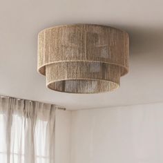 a light fixture hanging from the ceiling in a room with white walls and drapes