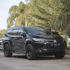 a black suv parked in front of some palm trees