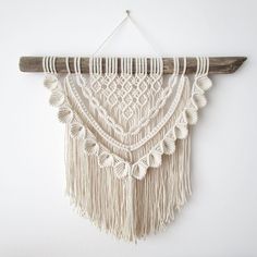 a wall hanging with macrame and tassels attached to the side of it