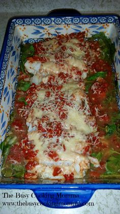 a casserole dish filled with meat, cheese and tomato sauce on top of lettuce