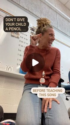 a woman sitting in front of a whiteboard talking to someone