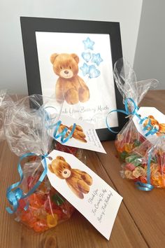 there are two bags of gummy bears on the table next to a card with a teddy bear