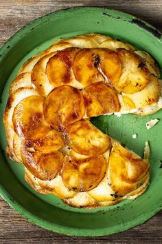 a green plate topped with a banana upside down cake on top of a wooden table