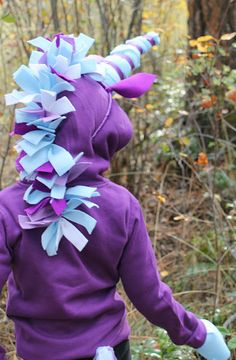 a young child wearing a purple and blue costume with horns on it's head