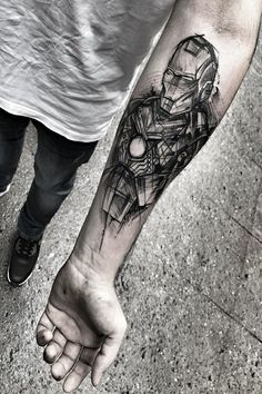 a man's arm with a black and white tattoo design on the left forearm