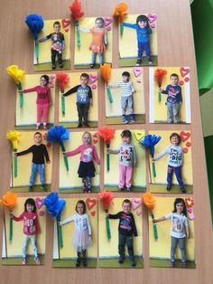 paper cut out of children's faces with flowers and hearts on them, sitting on a table