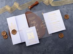 the wedding stationery is laid out on top of each other, with gold foil