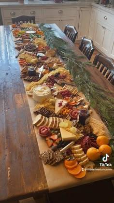 a wooden table topped with lots of different types of cheeses and crackers on top of it