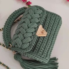 a green purse with a tasseled strap