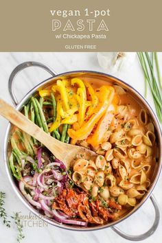 a pot filled with pasta and vegetables on top of a table