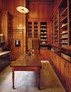 a large wooden kitchen with lots of cupboards and counter top space, including a dining room table