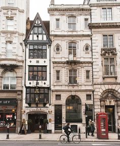 a group of buildings that are next to each other on a street with people walking by