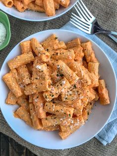 two bowls filled with pasta and sauce on top of a table