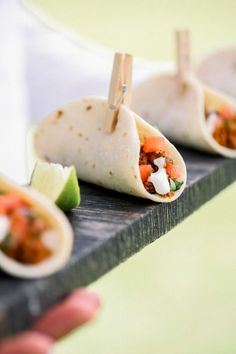 three burritos on a tray with toothpicks sticking out of them