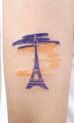 a person with a tattoo on their arm that has the eiffel tower painted on it