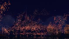 fireworks are lit up in the night sky over boats and castle at disney's magic kingdom