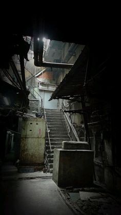 an old building with stairs leading up to the second floor and light coming from above