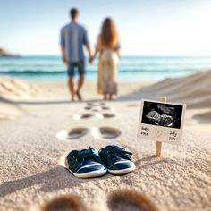 a couple walking on the beach with footprints in the sand and a sign that says, you're married here