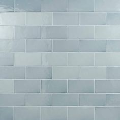 a white tiled wall in a bathroom