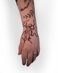 a hand with an octopus tattoo on it