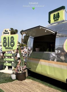 an airstream is parked on the grass with people standing around it and there is a sign that says 818