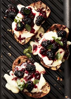 three pieces of bread with berries and cream on top