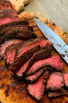 sliced meat on a cutting board with a knife