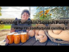 a woman sitting at a picnic table with jars of pumpkins and squash