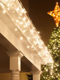 a christmas tree is lit up with lights on the top and below it, under an awning