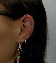 a close up of a person with ear piercings on their ears and behind the ear