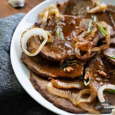 a white plate topped with meat and onions