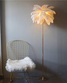 a floor lamp with a white feather shade next to a chair