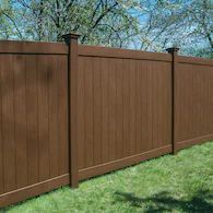 a brown wooden fence in the grass