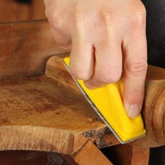 a person using a sponge to clean a piece of wood