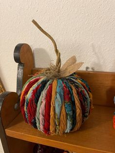 a wooden shelf topped with a multicolored pumpkin